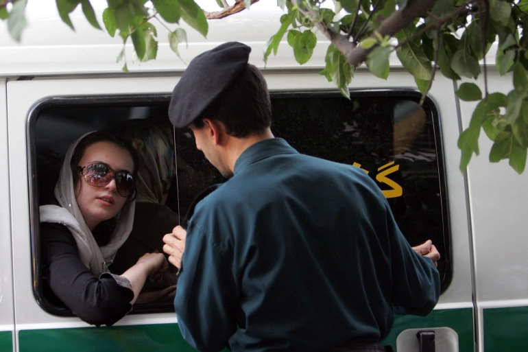 Một cảnh sát ở Iran nói chuyện với người phụ nữ trên xe do cô này “ăn mặc không phù hợp” (ảnh: Aljazeera)