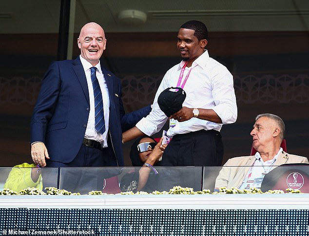 Eto'o đứng bên cạnh Chủ tịch FIFA tại khán đài sân vận động World Cup ở Qatar.