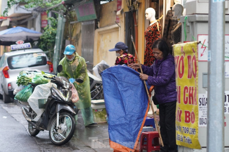 Người dân bắt đầu phủ áo mưa, che bạt chắn mưa chắn gió.