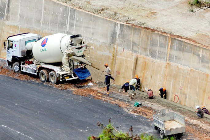 Nhóm công nhân đang thi công ở đoạn đèo gần khu du lịch cáp treo Đà Lạt. Ông Trần Văn Hiệp, Phó giám đốc Ban quản lý dự án giao thông tỉnh Lâm Đồng, cho biết dự kiến đoạn 3 km này có thể hoàn thành và đưa vào lưu thông vào cuối tháng 10-2023.