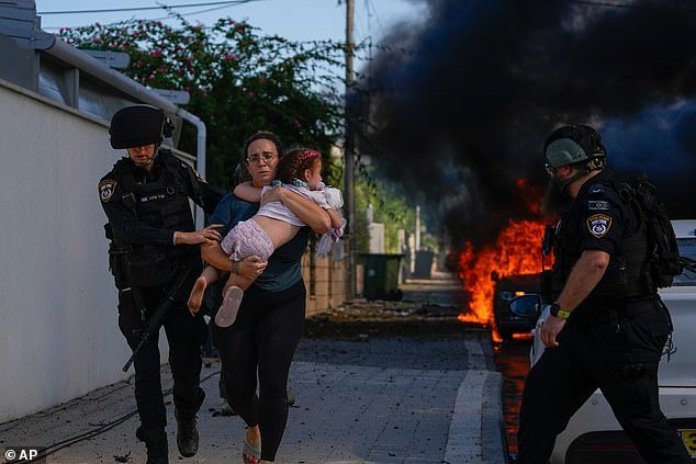 Một phụ nữ và trẻ em được sơ tán khỏi địa điểm bị Hamas tấn công rocket ở miền nam Israel ngày 7/10. Ảnh: AP