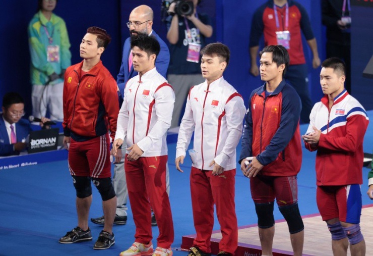 Á quân ASIAD 18 - Trịnh Văn Vinh (trái) cùng Nguyễn Trần Tuấn Anh (thứ 2 từ phải) và các lực sĩ cử tạ Trung Quốc, Triều Tiên dự tranh hạng 61 kg nam tại ASIAD 19. Ảnh: QUÝ LƯỢNG