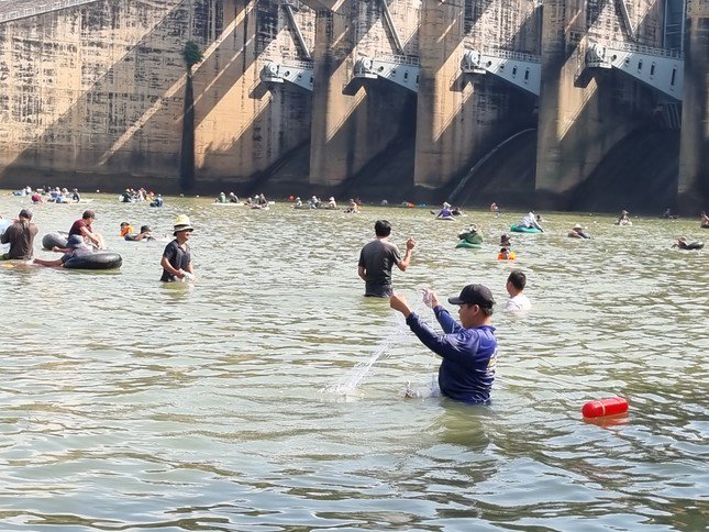 Ngay khi đập được đóng hoàn toàn, hàng trăm người ào xuống nước với các ngư cụ để bắt cá .