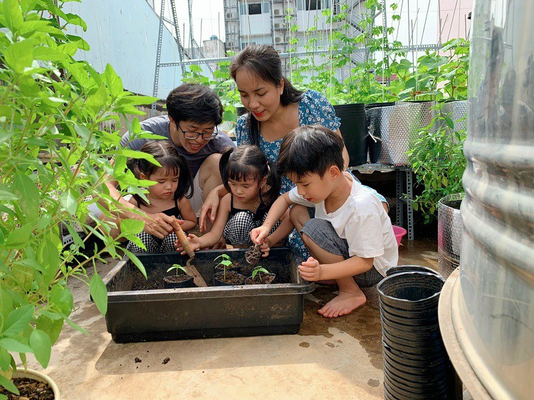 Cả gia đình chị Tiên cùng nhau trồng và chăm sóc cây trên sân thượng vào ngày nghỉ.