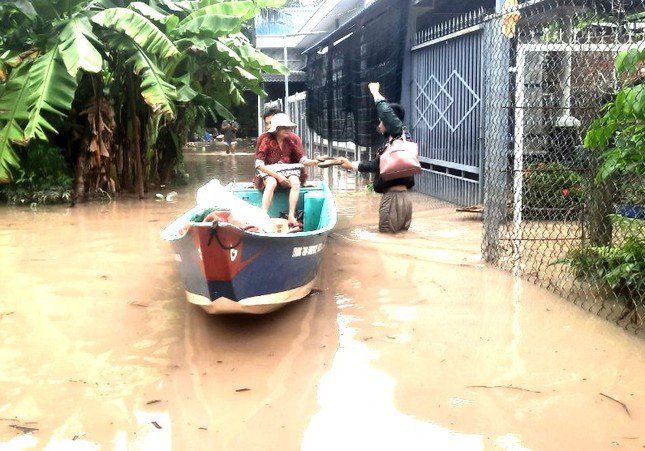 Người dân Bình Dương chèo xuồng trên đường phố sau cơn mưa lớn - 1