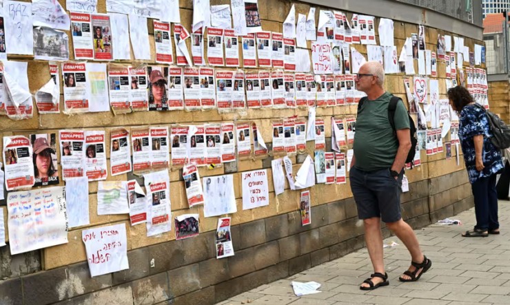 Người dân ở Tel Aviv, Israel nhìn vào những tờ thông báo tìm người bị Hamas bắt làm con tin. Ảnh: DEBBIE HILL/UPI