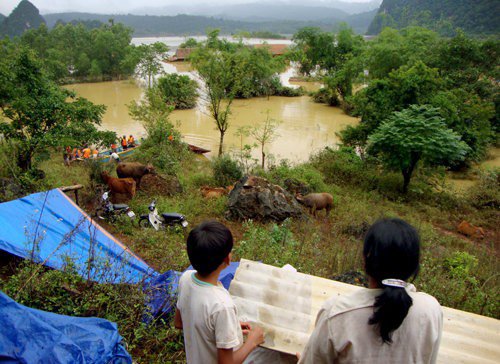 Vùng đất Tân Hoá là một thung lũng, 4 bề là vách núi đá vôi bao bọc. Chính vì thế, khi mưa to, nước từ khắp nơi đổ về gây nên lũ lụt ở đây. Trận lũ lịch sử năm 2010 nhấn chìm hơn 90% nhà cửa của người dân Tân Hoá, buộc họ phải chạy vào núi đá để tránh lũ lụt. Sau trận ngập lụt ấy, đã có ý tưởng di dời toàn bộ người dân Tân Hoá đi nơi khác để tránh lũ. Ảnh: Nguyên Linh.