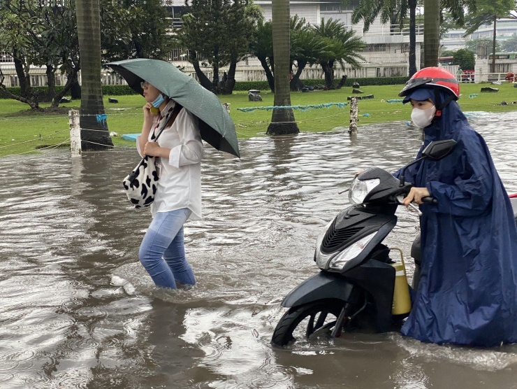 Công nhân bì bõm lội nước về nhà sau giờ tan ca.