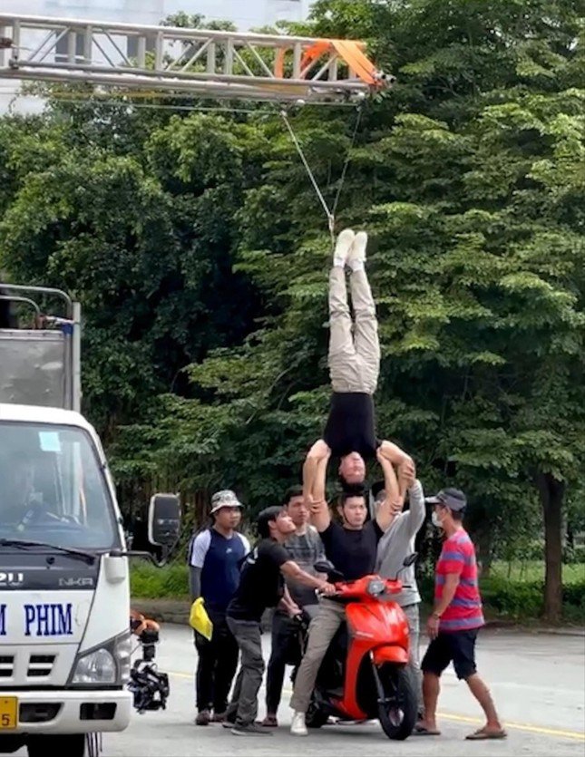 Nghệ sĩ Quốc Cơ - Quốc Nghiệp thực hiện động tác chồng đầu lên nhau khi đi xe máy có sự hỗ trợ của đoàn làm phim. Ảnh cắt từ clip gốc