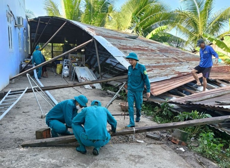 Lực lượng dân quân hỗ trợ người dân sửa chữa lại nhà bị tốc mái. Ảnh: DUY PHƯỚC