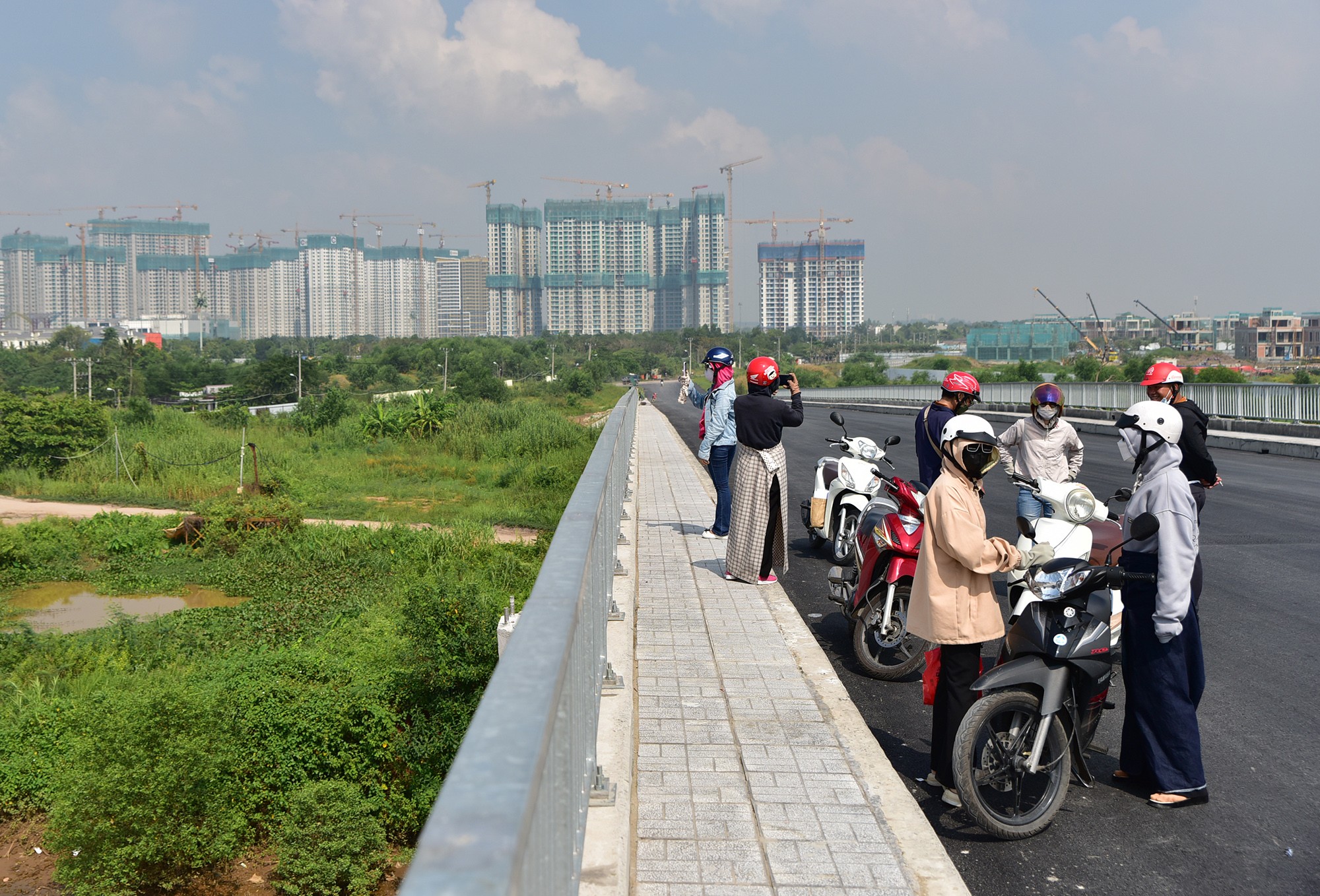 Trong những ngày qua, nhiều người dân tự ý điều khiển ô tô, xe máy qua lại cầu dù chưa được phép lưu thông. Số khác chạy xe máy tụ tập giữa cầu để chụp ảnh, hóng mát.