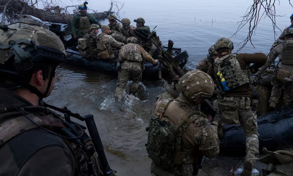 Binh sĩ Ukraine lên thuyền trên bờ sông Dnipro ở tiền tuyến gần Kherson (ảnh: Guardian)