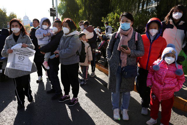 Người dân xếp hàng trước một bệnh viện nhi ở Bắc Kinh ngày 24/11. (Ảnh: Reuters)