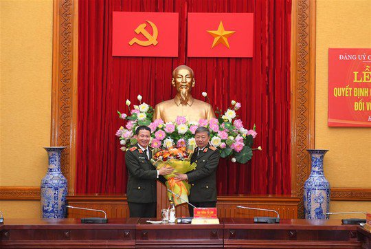Bộ trưởng Tô Lâm tặng hoa chúc mừng Thiếu tướng Vũ Hồng Văn. Ảnh: Bộ Công an