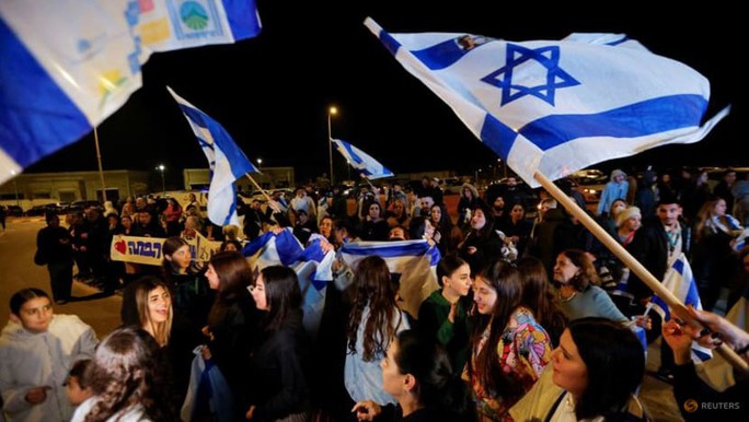 Người dân Israel vẫy cờ khi con tin do Hamas bắt giữ được trả tự do hôm 30-11. Ảnh: Reuters