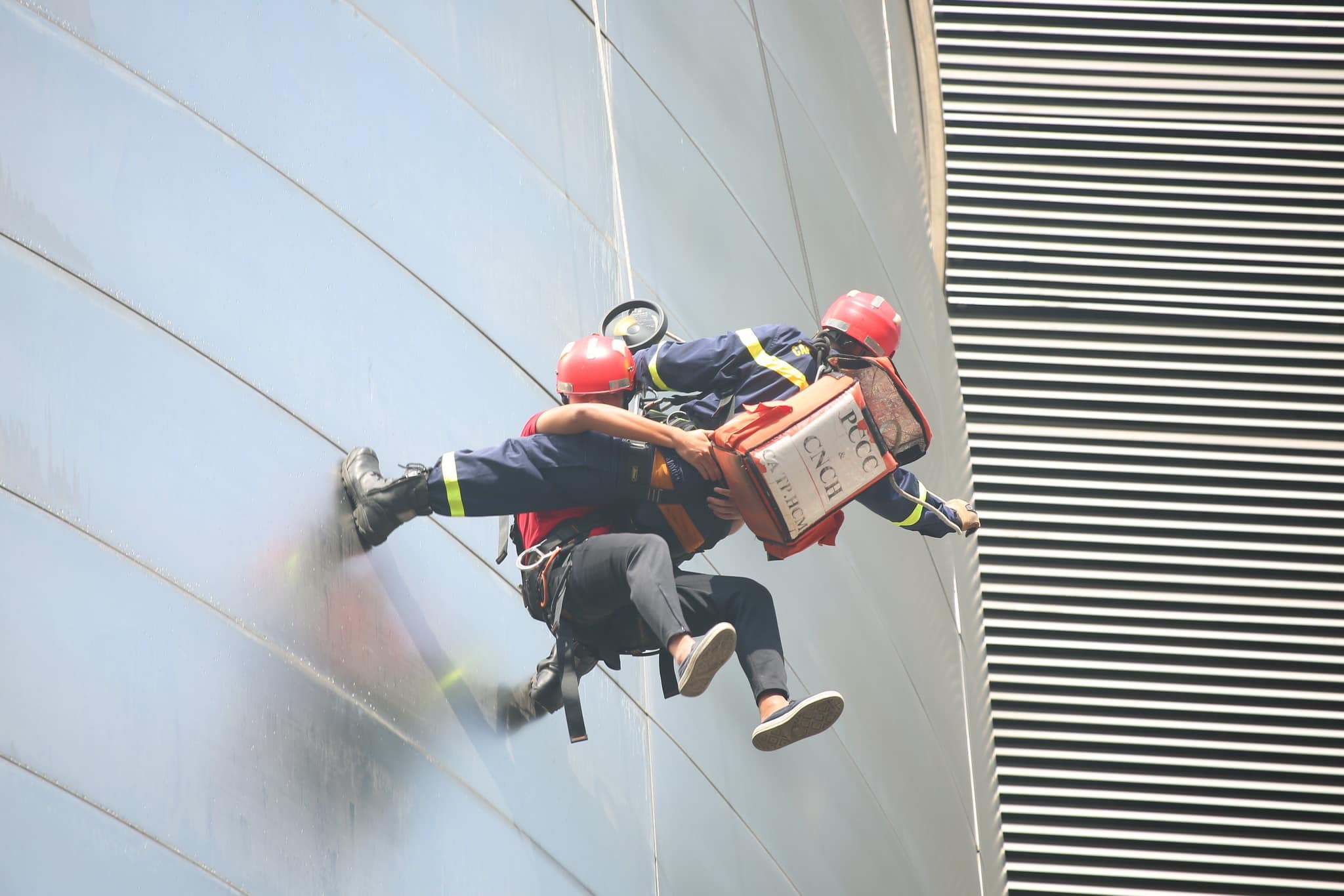 Cảnh sát đu dây giải cứu người mắc kẹt ra ngoài. Việc thực hiện có sự phối hợp nhịp nhàng cả hai bên để đảm bảo an toàn