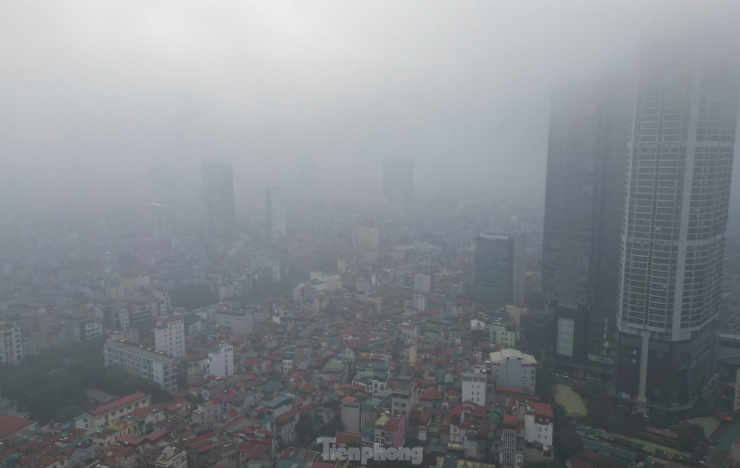 Sáng sớm 7/12, thủ đô Hà Nội bị lớp sương mù dày đặc bao phủ, tầm nhìn hạn chế, các tòa nhà cao tầng đều bị che khuất bởi màu trắng đục.