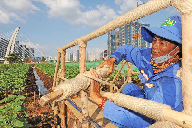 Người công nhân đang làm các tiểu cảnh phục vụ khách tham quan bên cạnh bến phà.