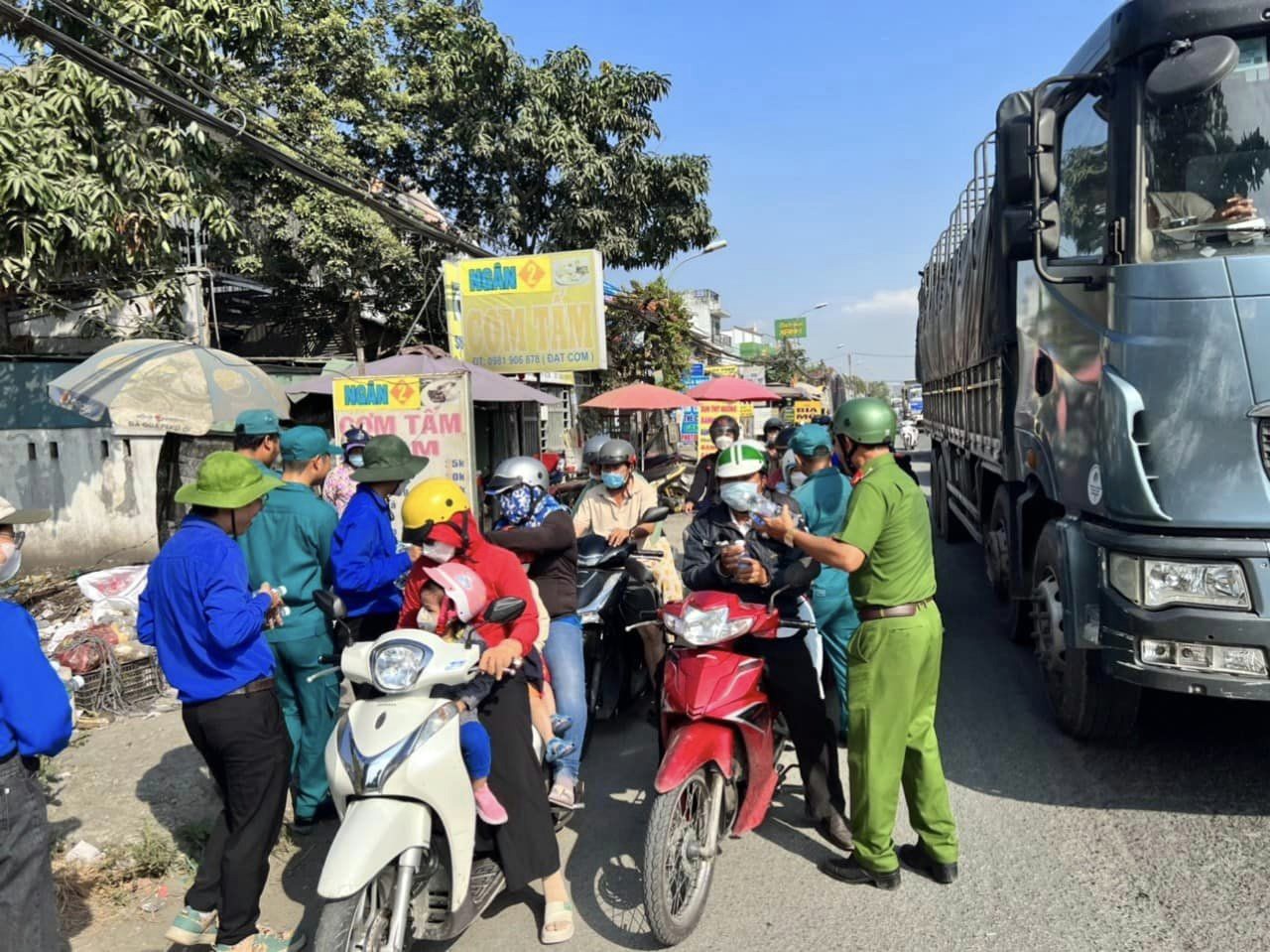 Ngoài việc phân luồng, điều tiết giao thông, hàng chục chiến sĩ CSGT, công an, đoàn viên thanh niên, dân quân đã trao tận tay người đi đường hàng trăm chai nước suối và tặng nón bảo hiểm.