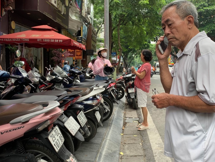 Người mua liên tục trao đổi với người thân bên trong tiệm vàng vì sốt ruột. Ảnh: Tiến Anh