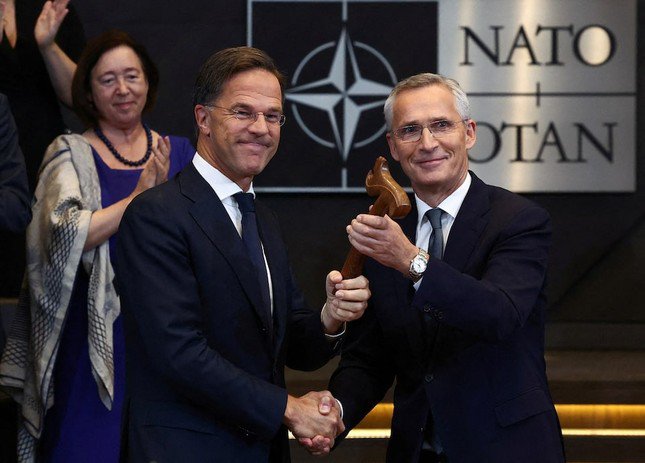 Cựu Tổng thư ký NATO Jens Stoltenberg bắt tay người kế nhiệm Mark Rutte. (Ảnh: Reuters)