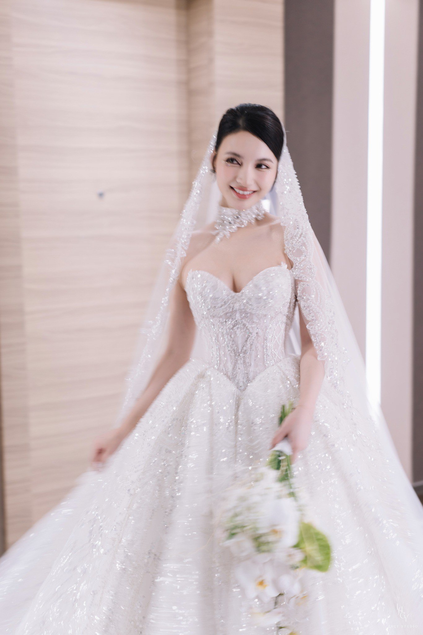 Trong đám cưới, Bích Thủy diện hai mẫu váy trị giá hơn 200 triệu đồng. Mẫu váy Ball Gown với phần tùng váy được nạm đá cùng kỹ thuật cắt laser để tạo độ bồng bềnh. Form váy dựng cấu trúc tôn lên vòng eo thon gọn với thiết kế corset siết eo tinh tế. Phần đính kết từ viền ngực kéo dài xuống tùng váy thu hút. Thiết kế này được thực hiện trong 6 tháng với 15 người thợ thủ công lành nghề và hơn 10.000 viên pha lê được nạm thủ công.