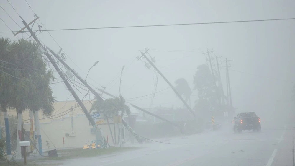 Những cột điện bị gió mạnh thổi gãy tại TP Fort Myers, bang Florida hôm 9-10. Ảnh: REUTERS