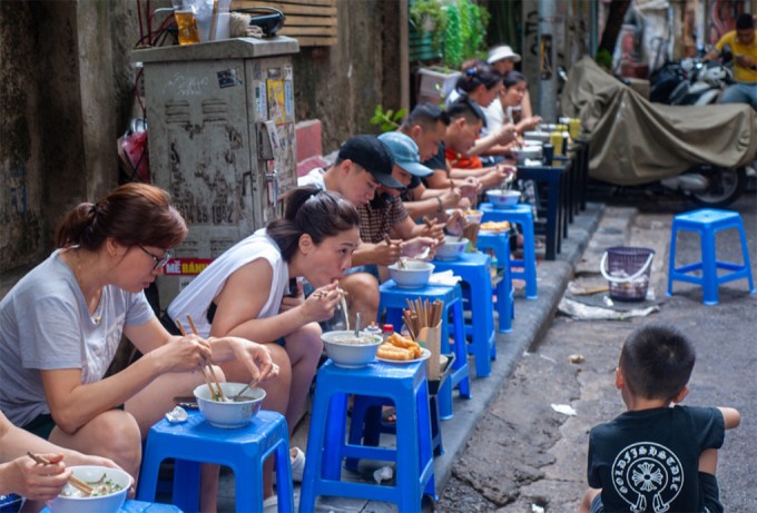 Khách ngồi ngoài vỉa hè ăn phở Ấu Triệu. Ảnh: Thế Bằng