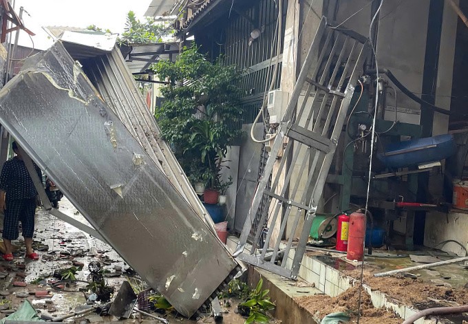 Hàng rào ngôi nhà cấp bốn bị xô lệch, hư hỏng sau vụ nổ. Ảnh: Minh Bằng
