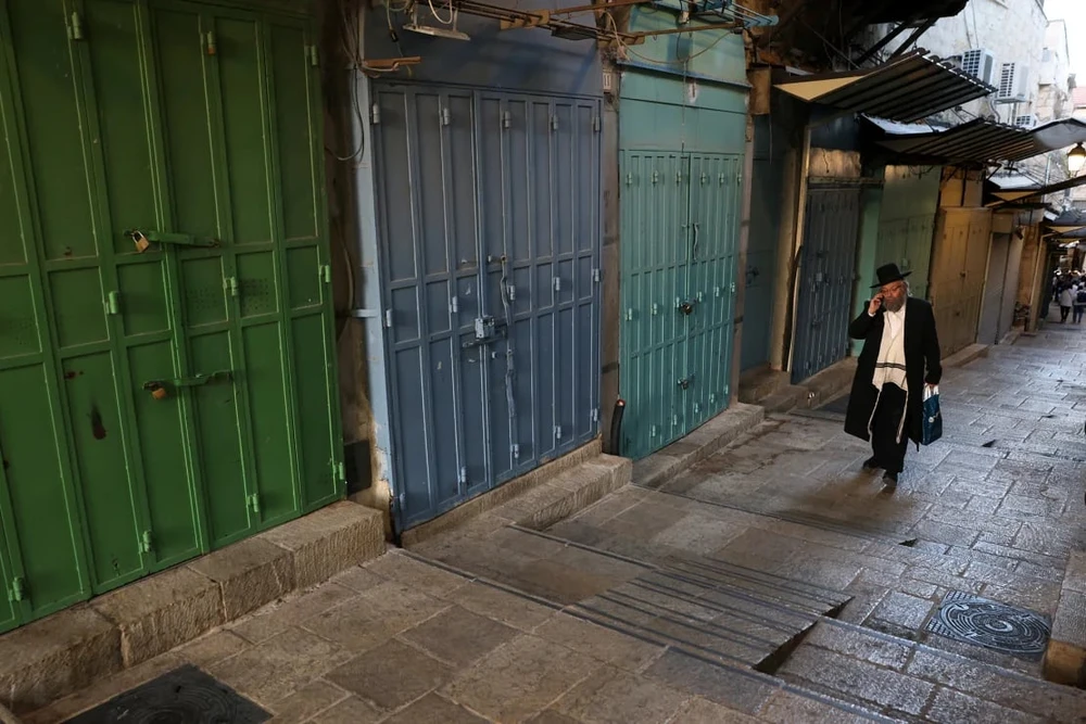 Một người đàn ông Do Thái đi ngang qua các cửa hàng đóng cửa ở TP Cổ Jerusalem vào ngày 11-9. Ảnh: AFP