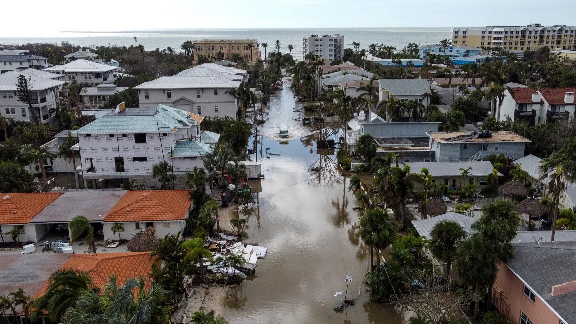 Trong bức ảnh trên không này, một chiếc xe chạy qua con phố bị ngập sau cơn bão Milton, ở Siesta Key, Florida, vào ngày 10 tháng 10 năm 2024.&nbsp;