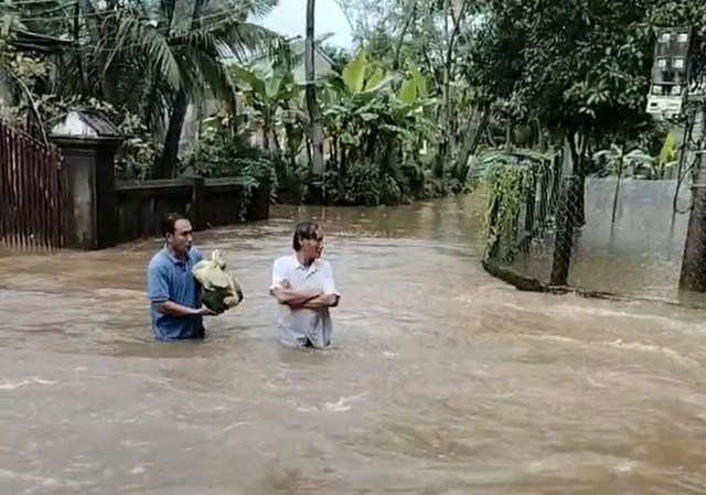 Người đàn ông can đảm cõng con gái nhỏ trên vai vượt nước lũ chảy xiết