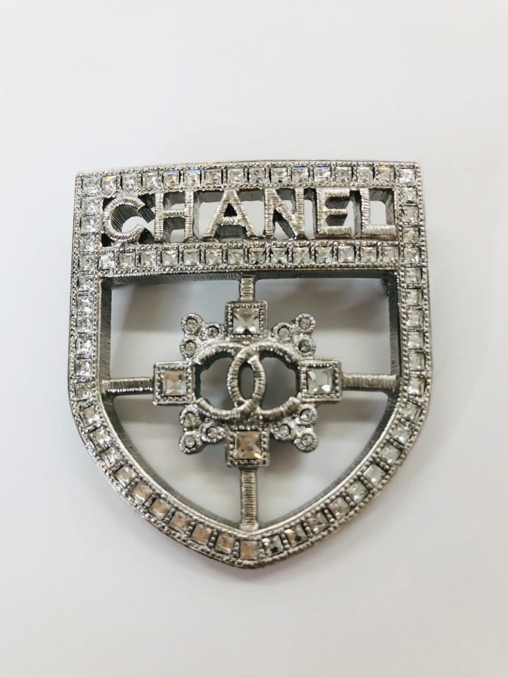 Vợ đại gia Minh "Nhựa" đeo thêm cài áo Chanel hình chiếc khiên 825 USD (21 triệu đồng).