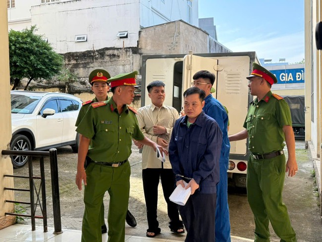 Công an dẫn các bị cáo vào phiên tòa