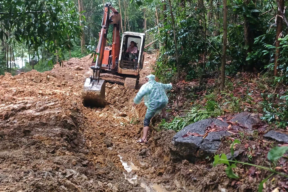 Xe cơ giới tạo mương chia nước trên đỉnh núi phía sau khu dân cư Nà Nổ.