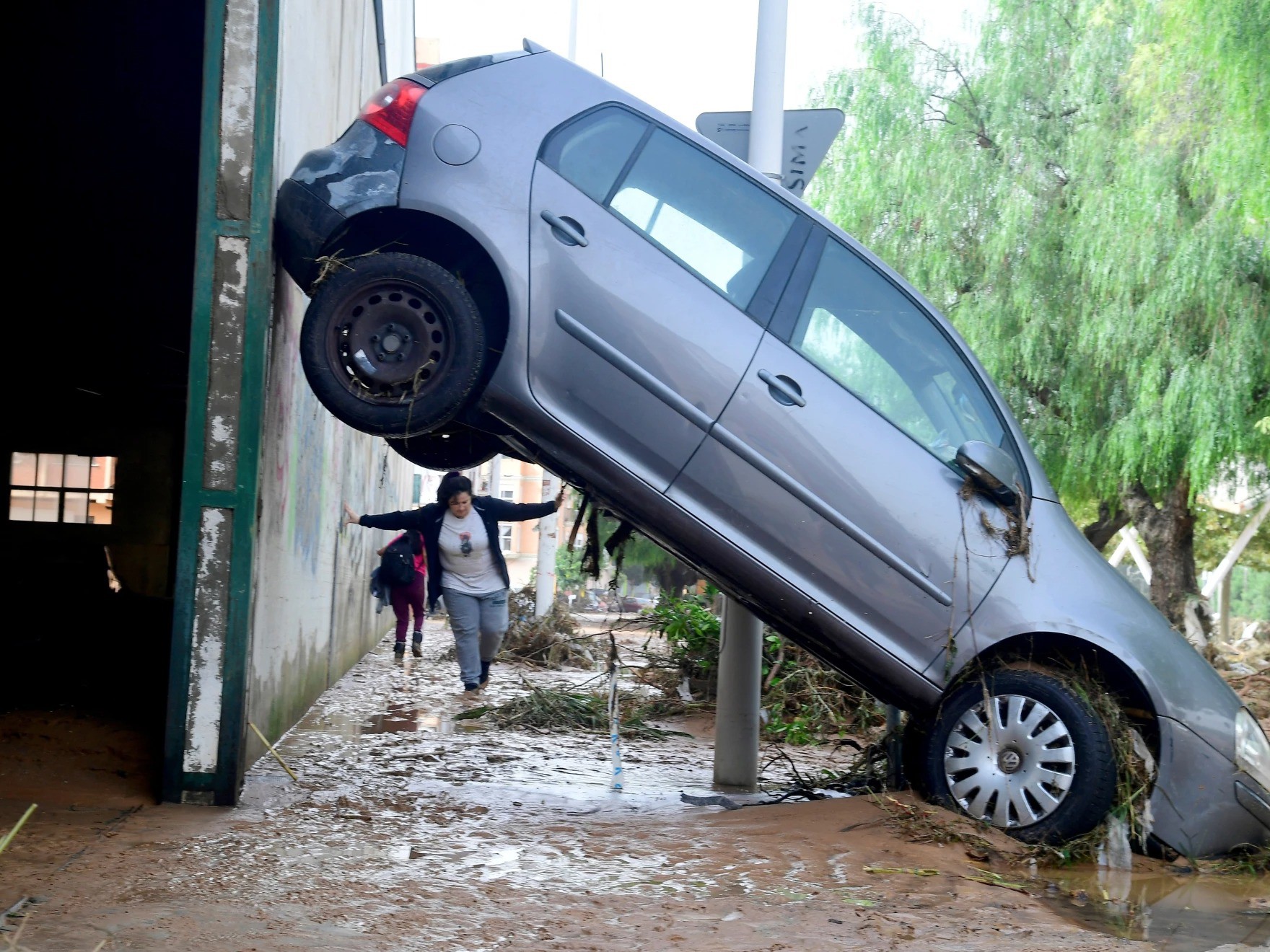 Một người dân đi bộ trên đường phố đầy bùn đất ở khu dân cư Picanya, gần thành phố Valencia. Ảnh: Getty