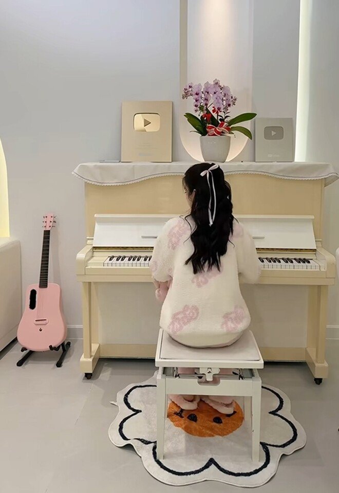 Mie còn bố trí một góc lãng mạn đặt đàn piano trắng hay chiếc guitar hồng và trưng bày ở đó nút vàng, nút bạc Youtube cũng như một lẵng hoa xinh xắn.