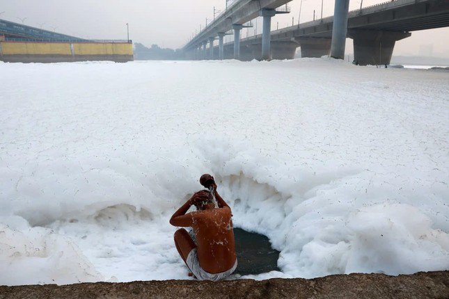 Một người đàn ông thản nhiên múc nước sông Yamuna đang nổi bọt để tắm. Ảnh: EPA-EFE.