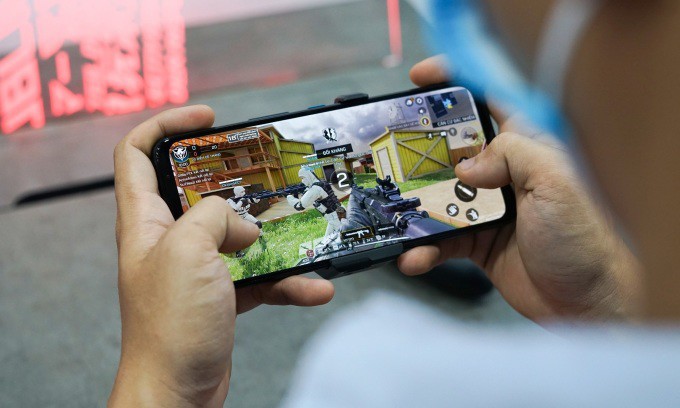 Một người dùng đang chơi game trực tuyến trên điện thoại. Ảnh: Bảo Lâm