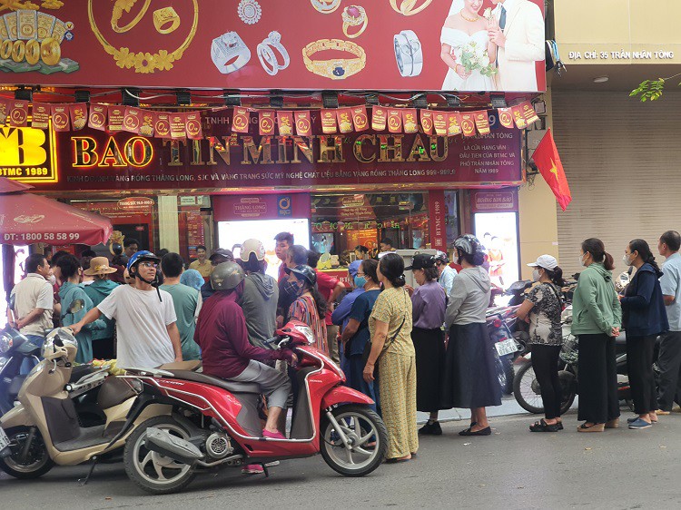 Dòng người mỗi lúc một kéo dài, đứng hết vỉa hè, xuống cả lòng đường khi cửa hàng chưa mở cửa.