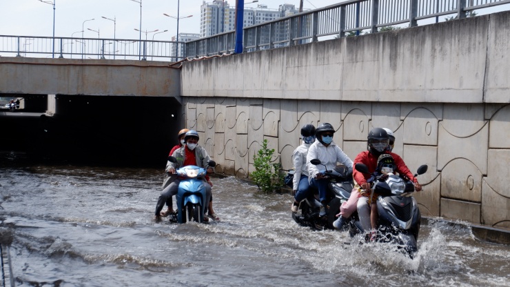 Người dân "bơi" qua biển nước.