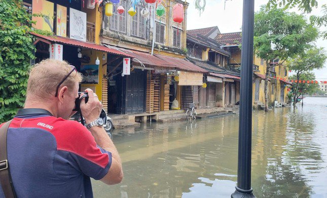 Nhiều du khách, nhất là khách Tây bì bõm lội nước, chụp hình khoảnh khắc Hội An mùa lụt.