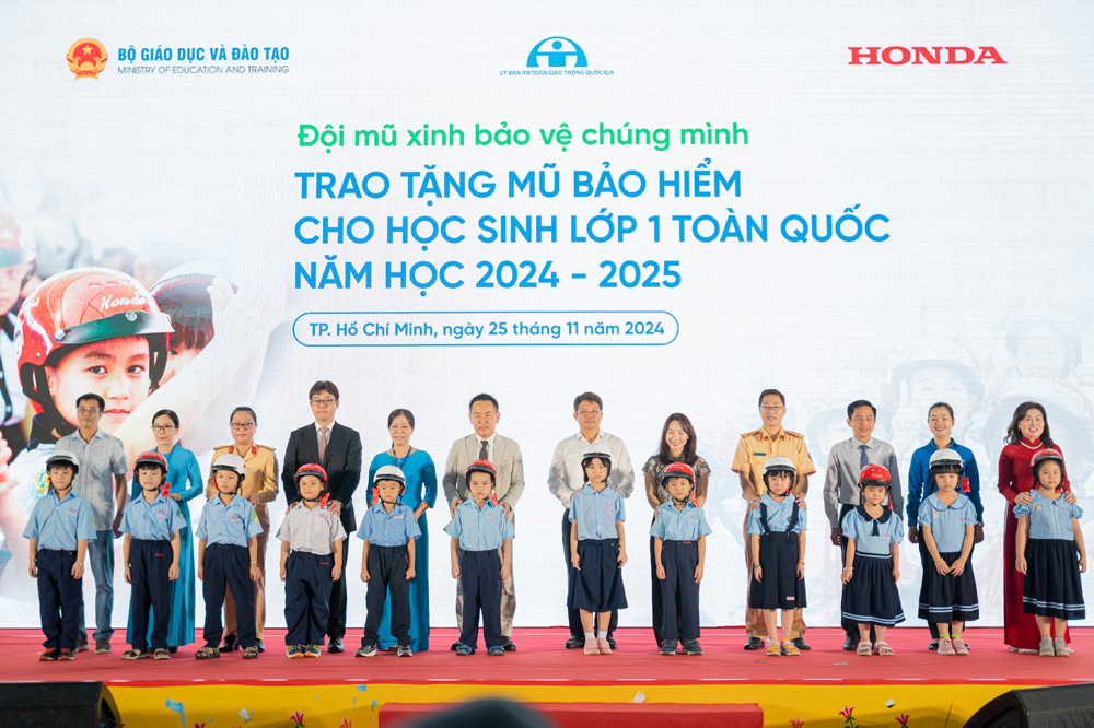 Các đại biểu trao tặng mũ bảo hiểm cho các em học sinh lớp Một trường Tiểu học Giồng Ông Tố&nbsp;