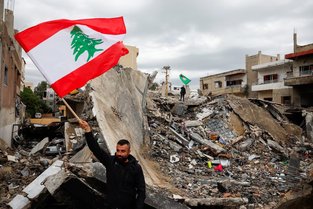 Người đàn ông Lebanon vẫy cờ, ăn mừng lệnh ngừng bắn (ảnh: Reuters)