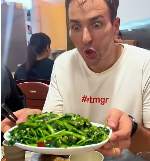 Will thưởng thức món rau muống xào tỏi trong một quán bia hơi ở Hà Nội