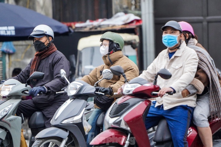 Để đối phó với gió lạnh, ngoài áo ấm, người dân ra đường cũng không quên tự trang bị khăn, mũ, khẩu trang...