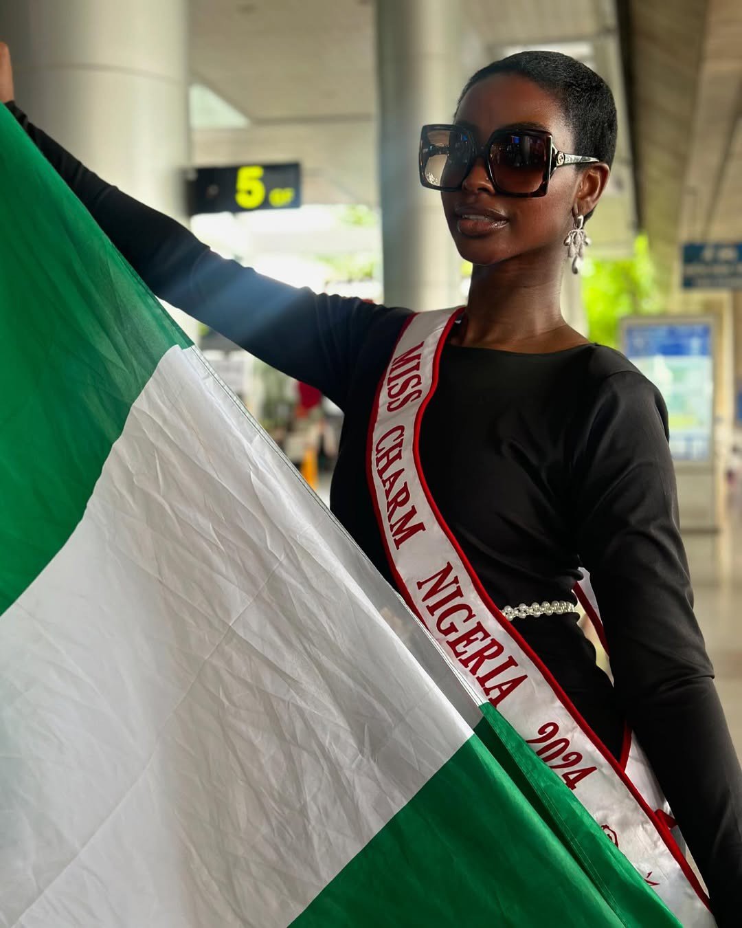 Miss Charm Nigeria - Hannah Onosetale Iribhogbe - mang theo cờ Tổ quốc.