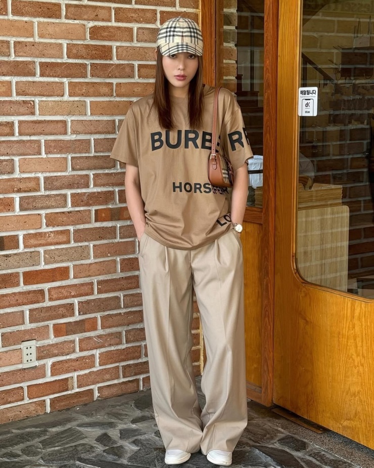 Thiết kế freesize của Burberry phối tông xuyệt tông quần màu be, túi đồng thương hiệu.