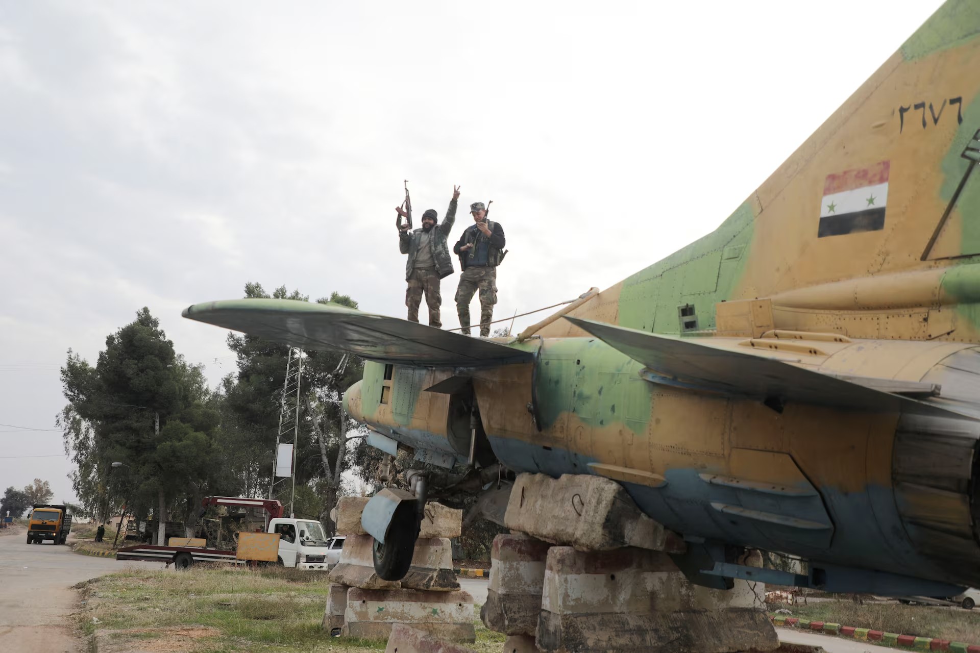 Chiến binh thuộc phe đối lập đứng trên một chiến đấu cơ của quân đội Syria (ảnh: Reuters)