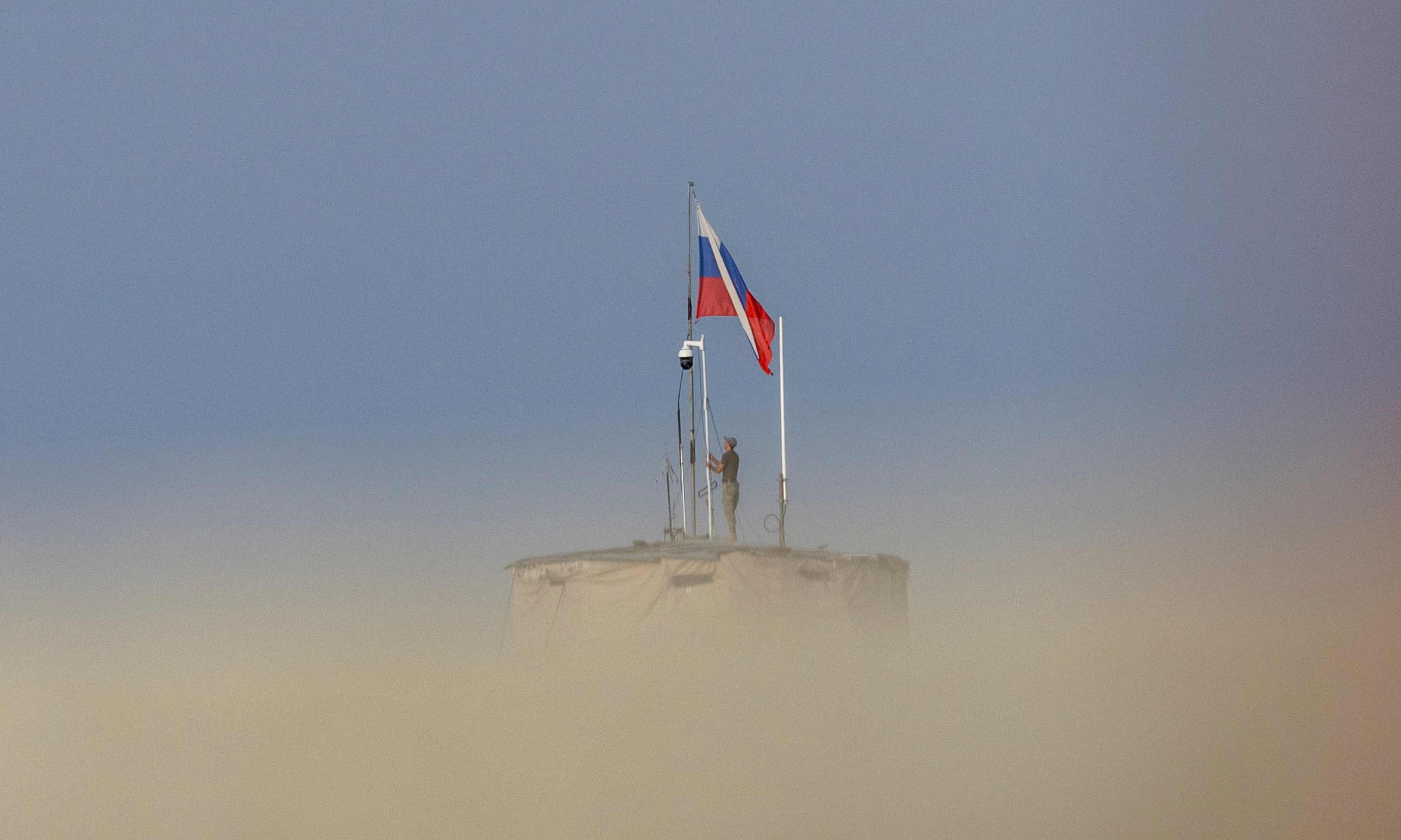 Binh sĩ Nga kéo cờ tại căn cứ không quân Khmeimim ở tỉnh Latakia, Syria. Ảnh: Reuters.